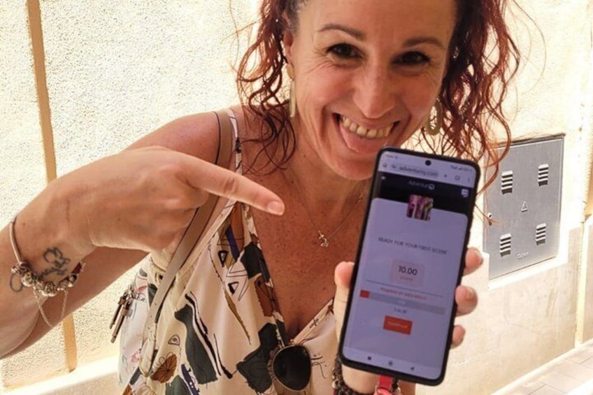 A person holding a smartphone displaying a price of 10.00. 1