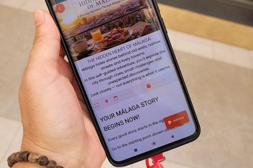 A smartphone displaying a travel article about Málaga. 2