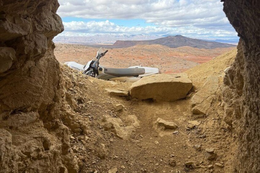 A rugged terrain with a vehicle and a large rock formation. 2