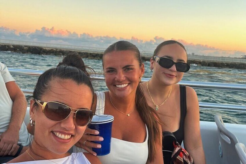 Three people on a boat with a sunset in the background. 3