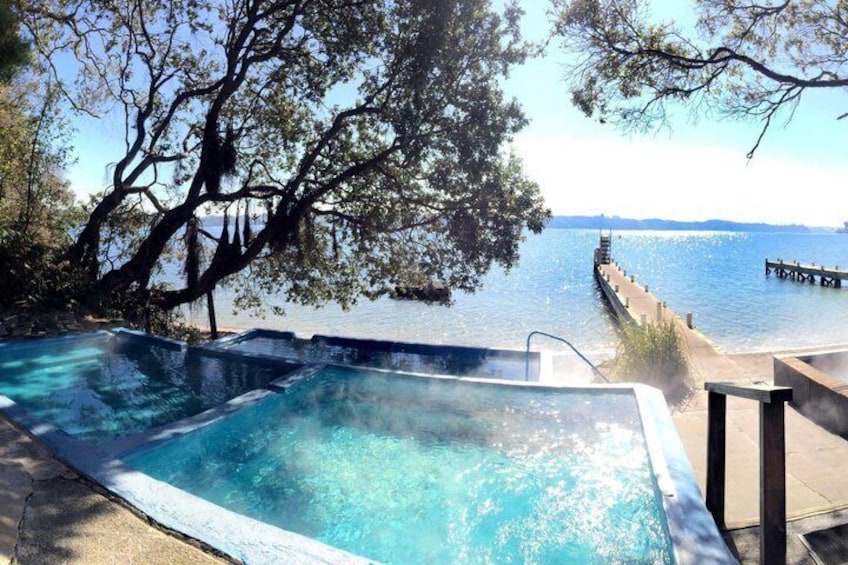 A hot tub by a lake with a dock extending into the water. 1