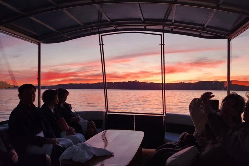 A sunset over a body of water with people on a boat. 2