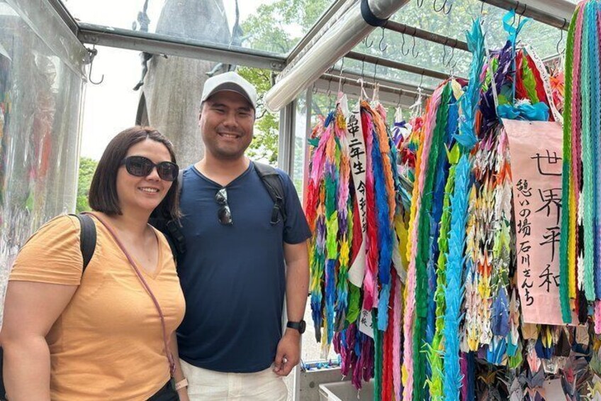 Two people standing in front of a colorful display of ribbons with Japanese text. 3