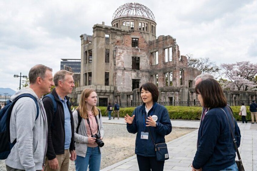 A group of people standing in front of a large, historic building with a dome structure. 1