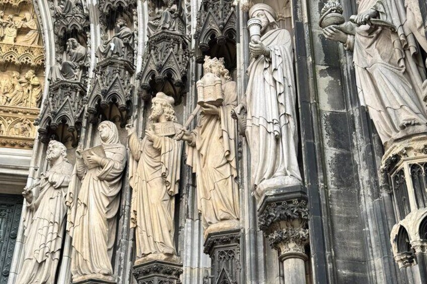 A detailed stone facade with Gothic architectural elements, including statues and ornate carvings. 4