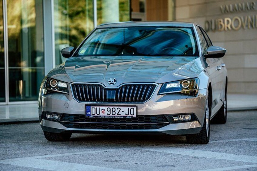 A silver car parked in front of a building with a sign that reads 'VALMAR DU BROWN'. 3