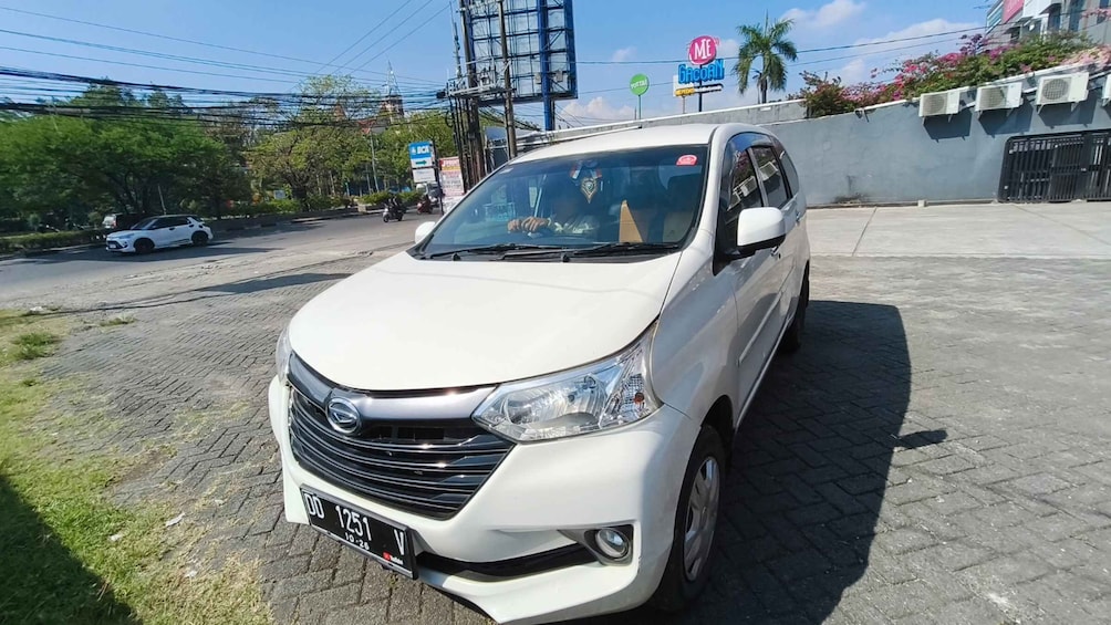 A white van parked on a paved area with a license plate. 3