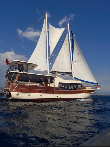 A sailing yacht with a white hull and a red flag, sailing on the water. 3
