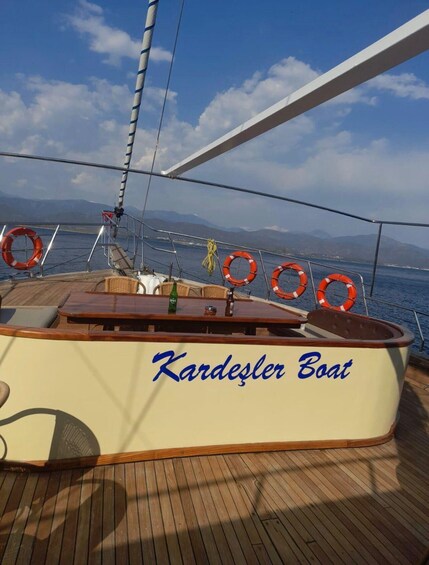 A boat named 'Kardesler Boat' with lifebuoys and a wooden deck. 4