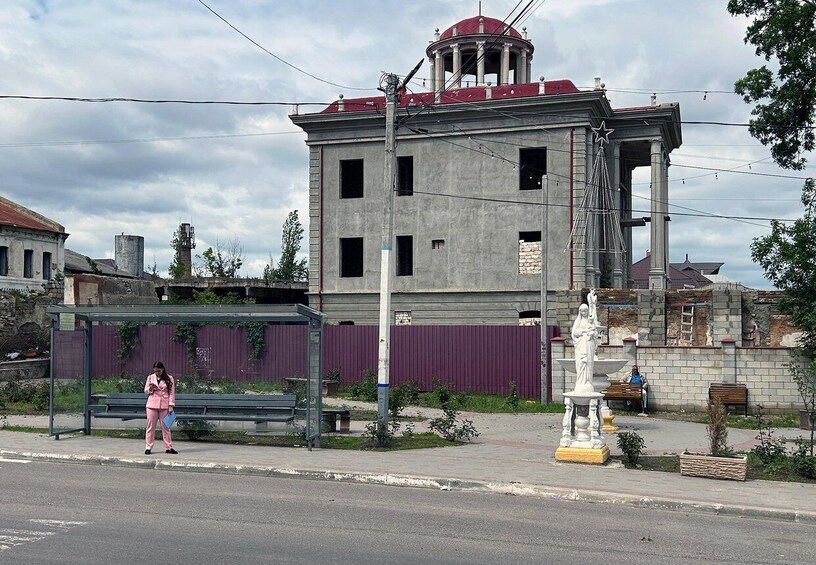 A building under construction with a statue in front. 4