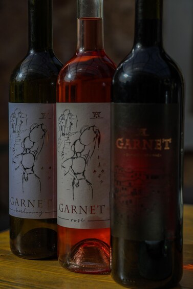 Three wine bottles with labels, one labeled 'Garnet chardonnay' and another 'Garnet rose.' 4