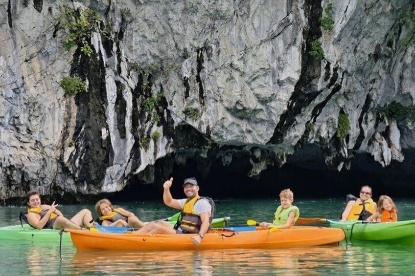 People kayaking on a calm river with rocky cliffs in the background. 5
