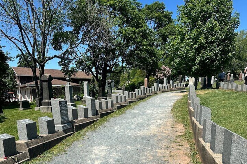 A cemetery with headstones and a pathway. 2