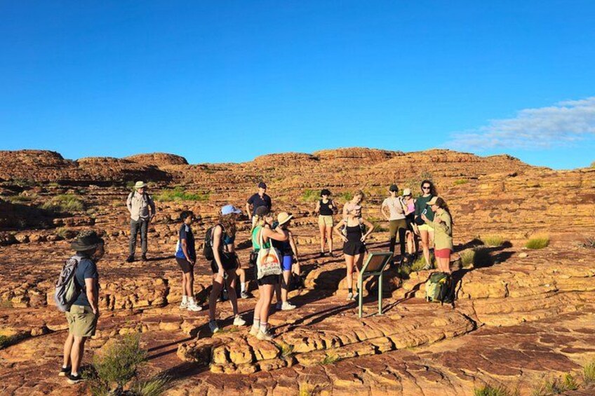 A group of hikers on a rocky terrain with a clear sky. 3