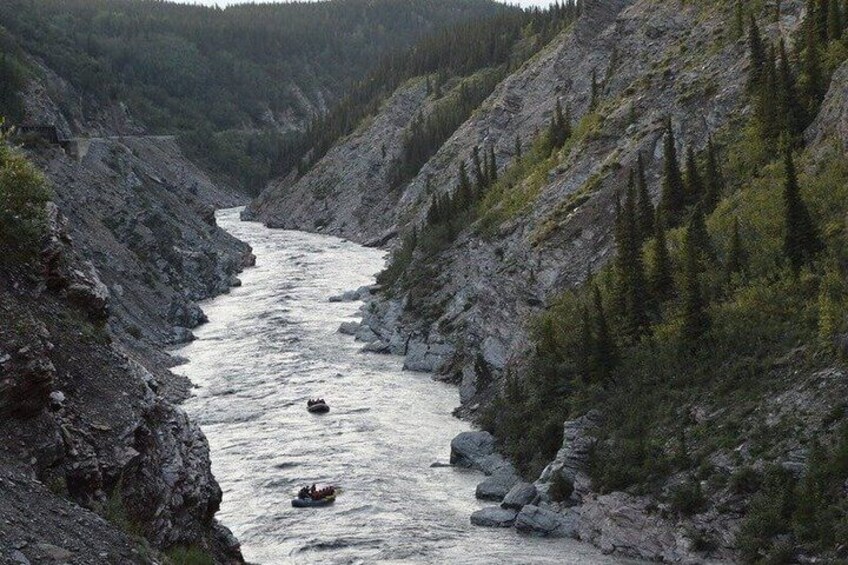 A river flowing through a rocky canyon with a small boat. 3