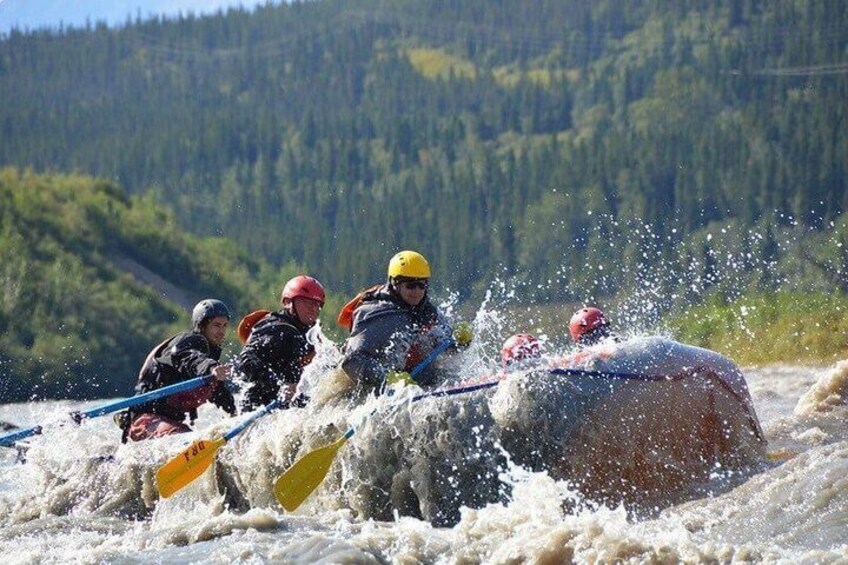 A group of people in kayaks navigating a river with splashes. 4