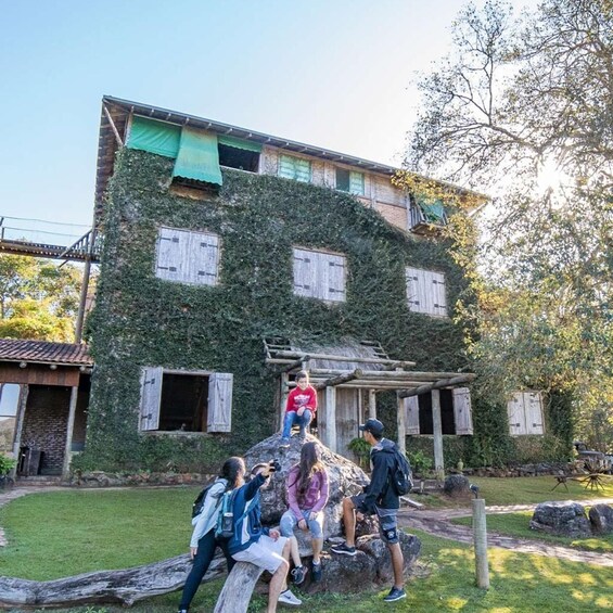 A building covered in ivy with a group of people around it. 3
