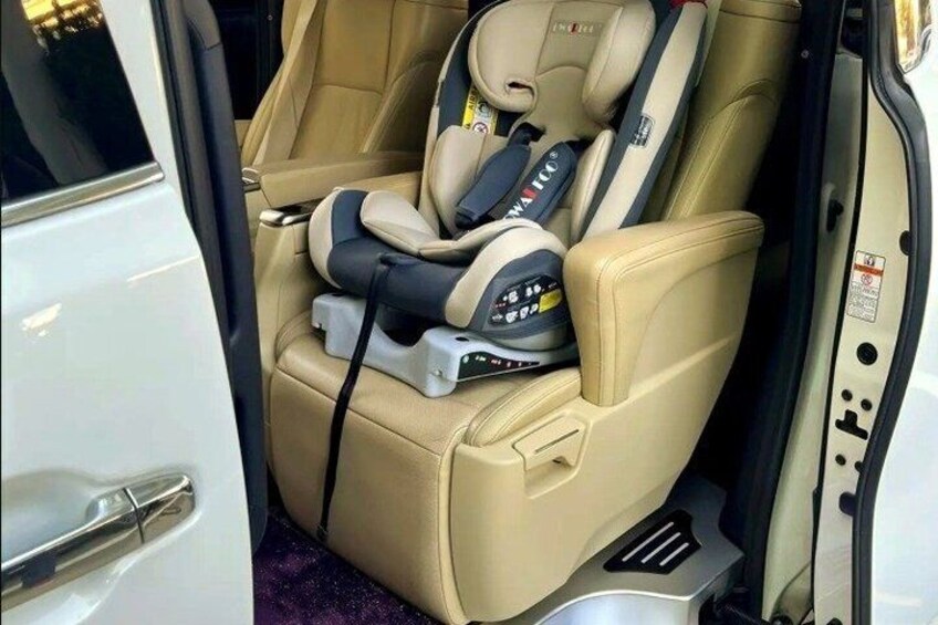 A massage chair with a control panel and a child seat in a vehicle. 2
