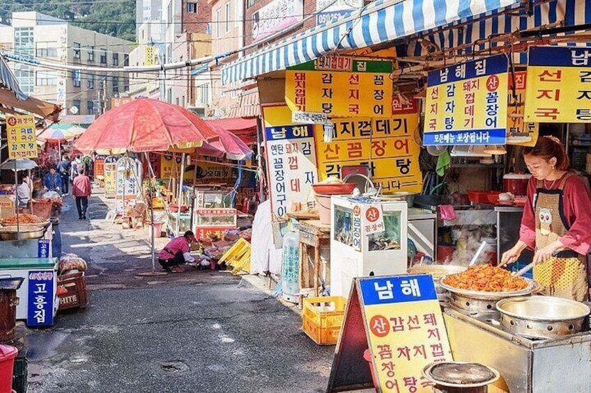 A bustling street market with various stalls, signs, and people. 4