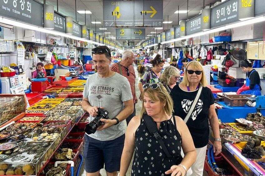 An indoor market with various stalls selling seafood and other goods. 4