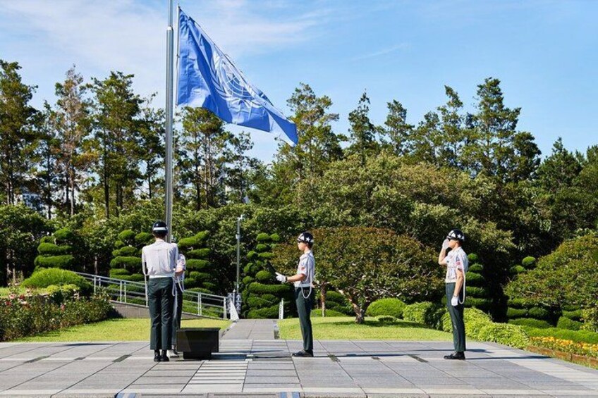Three people standing in a park with a flagpole and a flag. 5