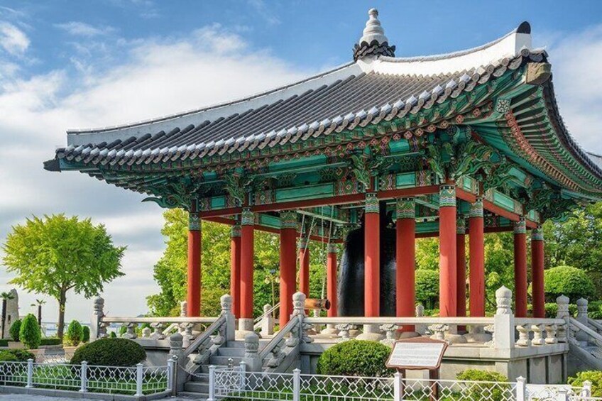 A traditional Korean pavilion with ornate roof and red pillars. 5