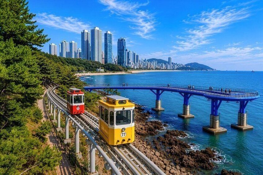 A coastal cityscape with a tram track, a bridge, and high-rise buildings. 1