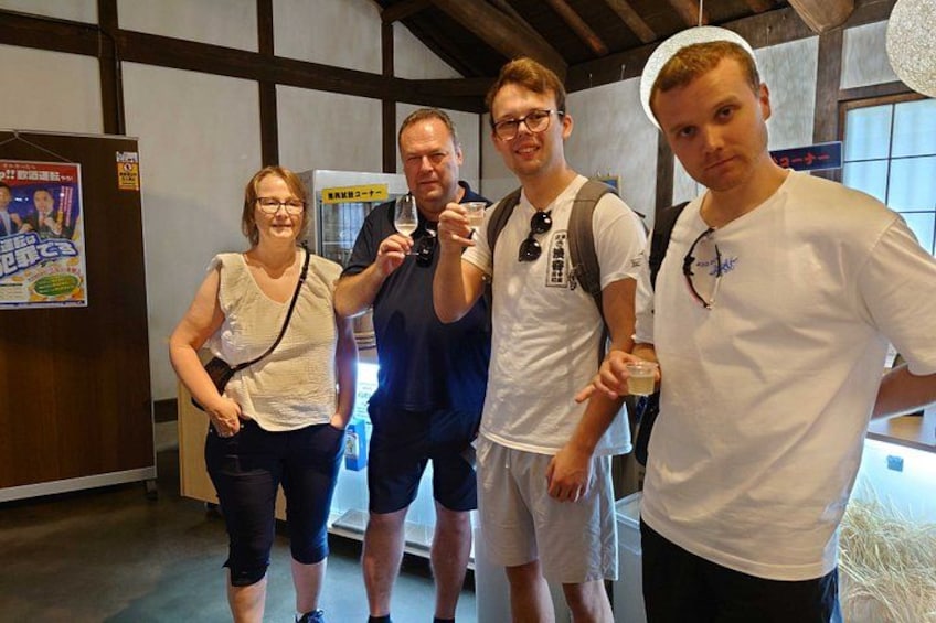 A group of people in an indoor setting with wooden beams on the ceiling and a poster on the wall. 3