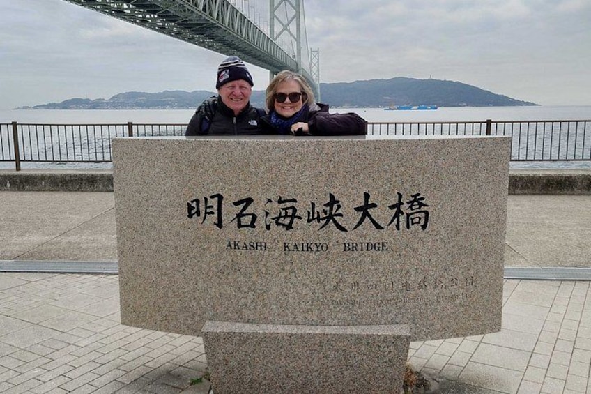 A stone plaque with the text 'Akashi Kaikyo Bridge' in both Japanese and English, with a view of the bridge and the sea in the background. 2