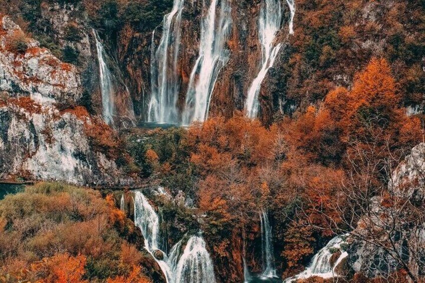 A multi-tiered waterfall surrounded by autumn-colored trees. 2