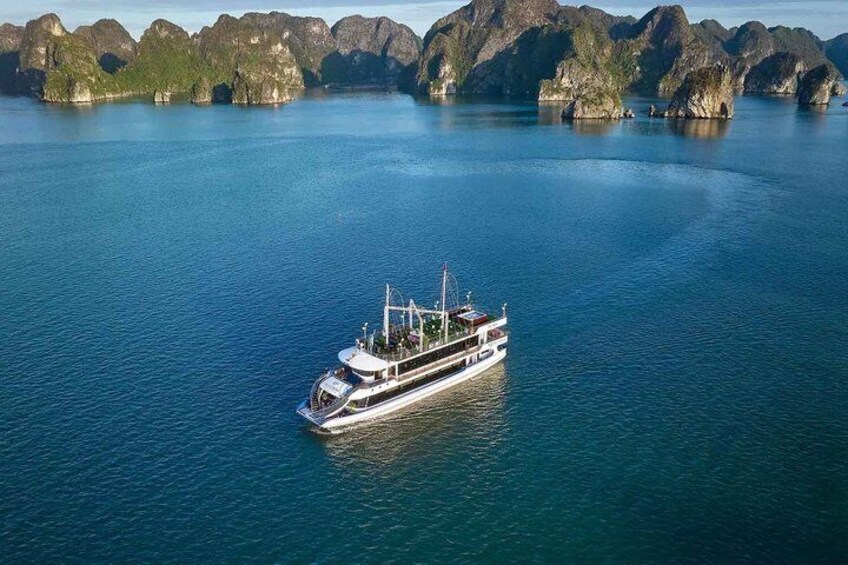A white cruise ship on calm waters with a backdrop of rocky islands. 1