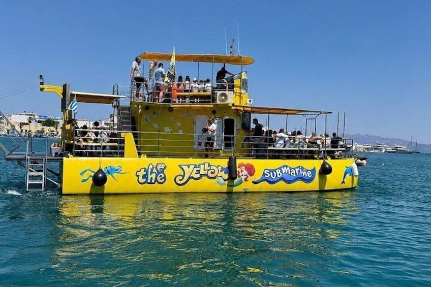 A yellow submarine-themed boat with passengers on deck, surrounded by calm blue water. 2