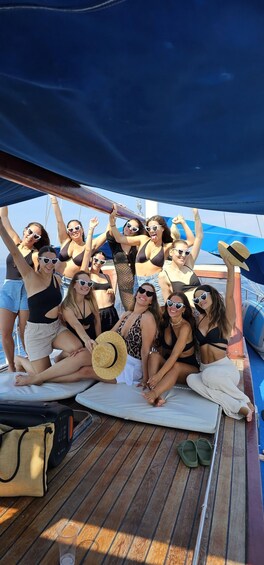 A group of people on a boat with a blue canopy, some wearing sunglasses and hats. 3