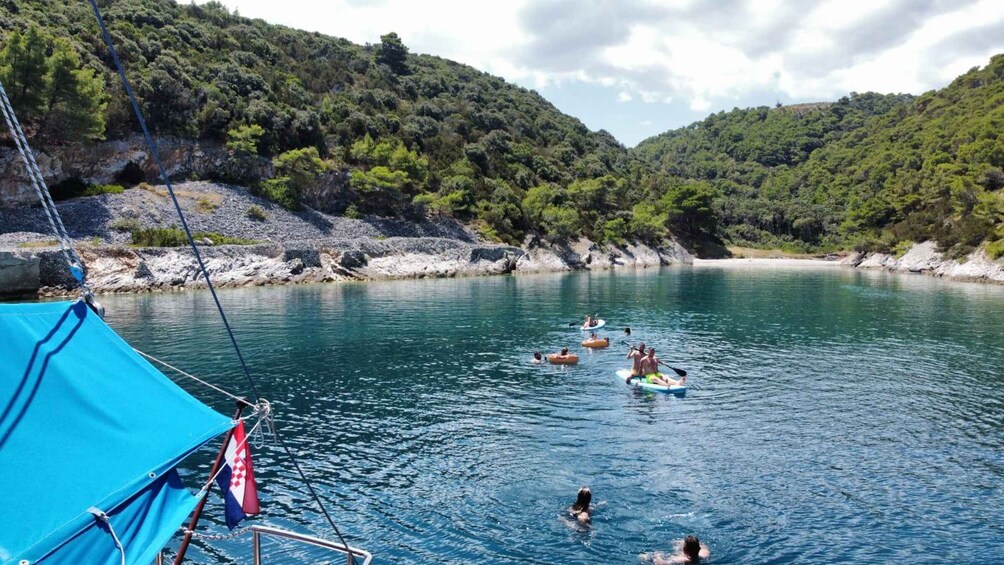 People on paddleboards in a calm lake surrounded by hills. 2