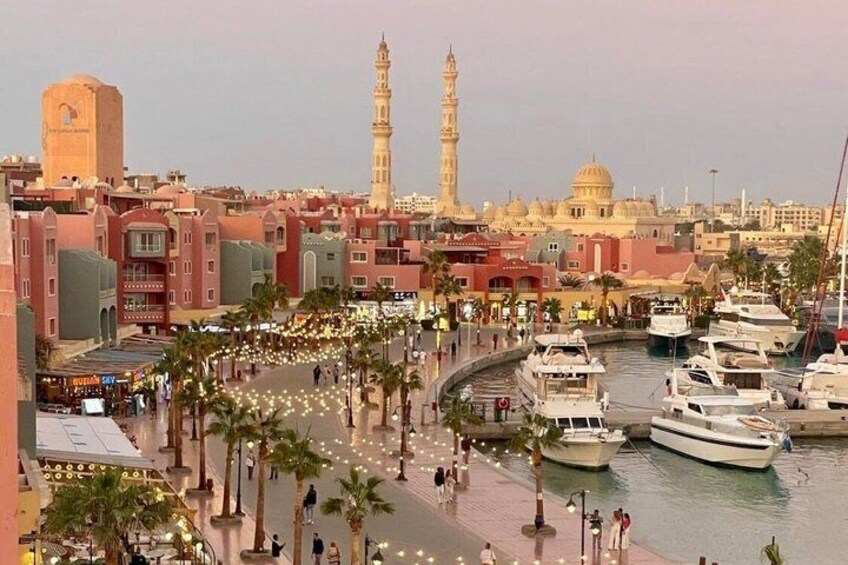 A marina with boats, palm trees, and historic buildings with minarets. 1