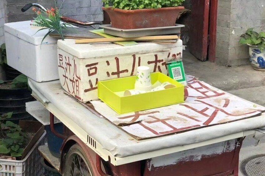 A table with a yellow box, a white container, and a potted plant. 4