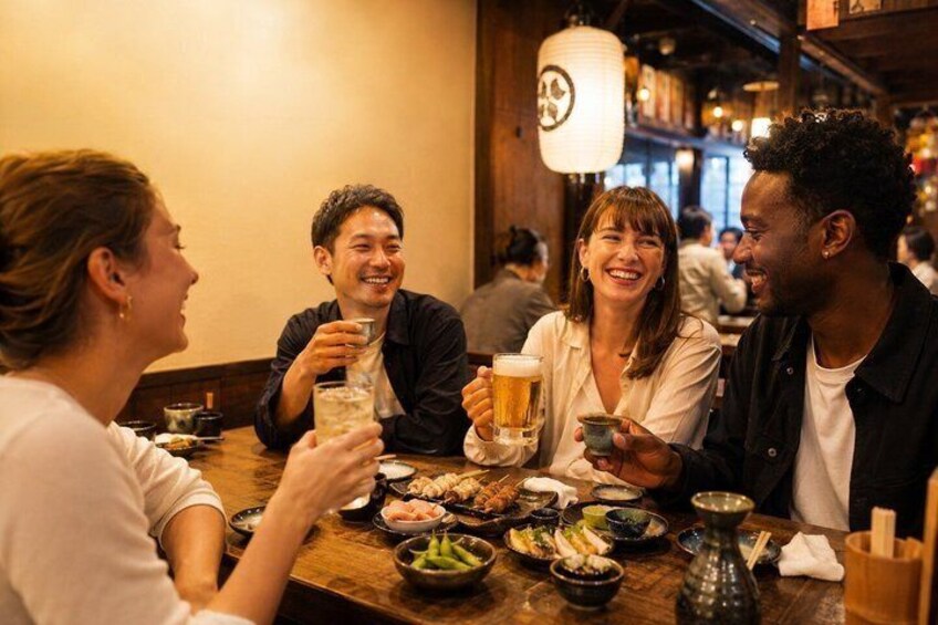 A group of people dining at a restaurant with various dishes and drinks on the table. 2