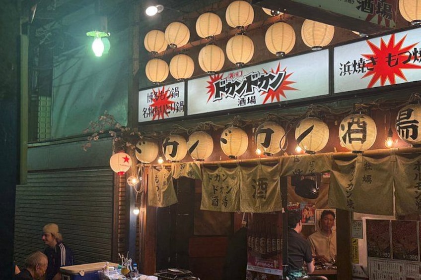 A traditional Japanese street food stall with lanterns and signage. 3