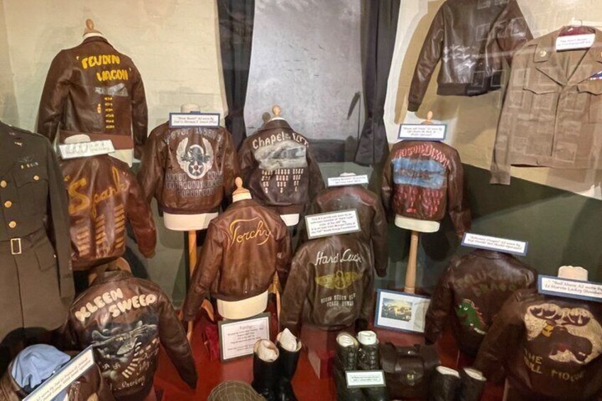 A display of vintage leather jackets with various designs and text on the back. 1
