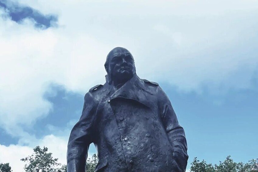 A statue of a person wearing a jacket, standing outdoors. 1