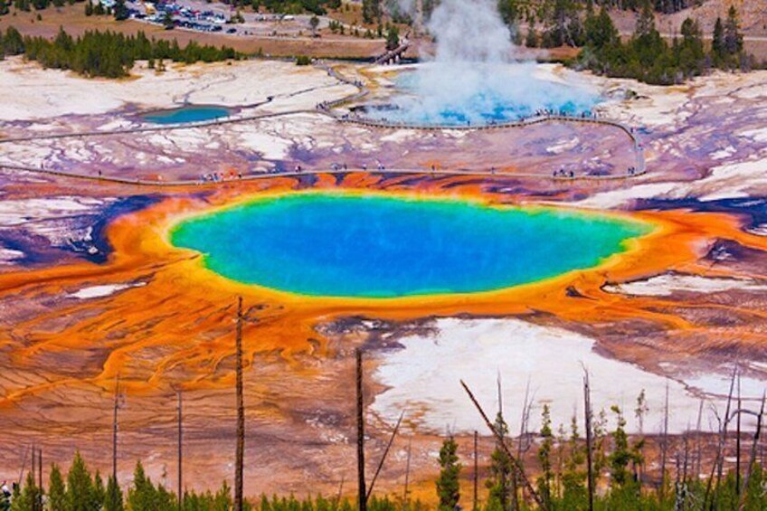 A colorful geothermal area with a large blue pool surrounded by orange and red mineral deposits. 3
