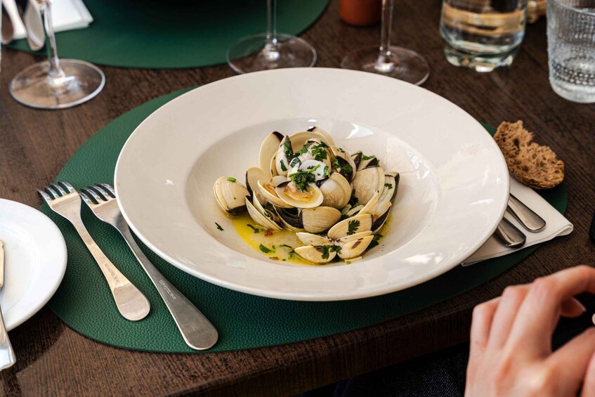 A plate of clams with a garnish, placed on a green placemat. 4