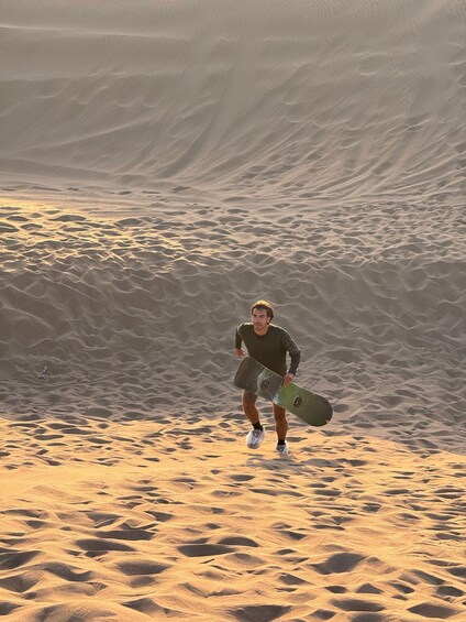 A person running with a snowboard in a desert landscape. 3