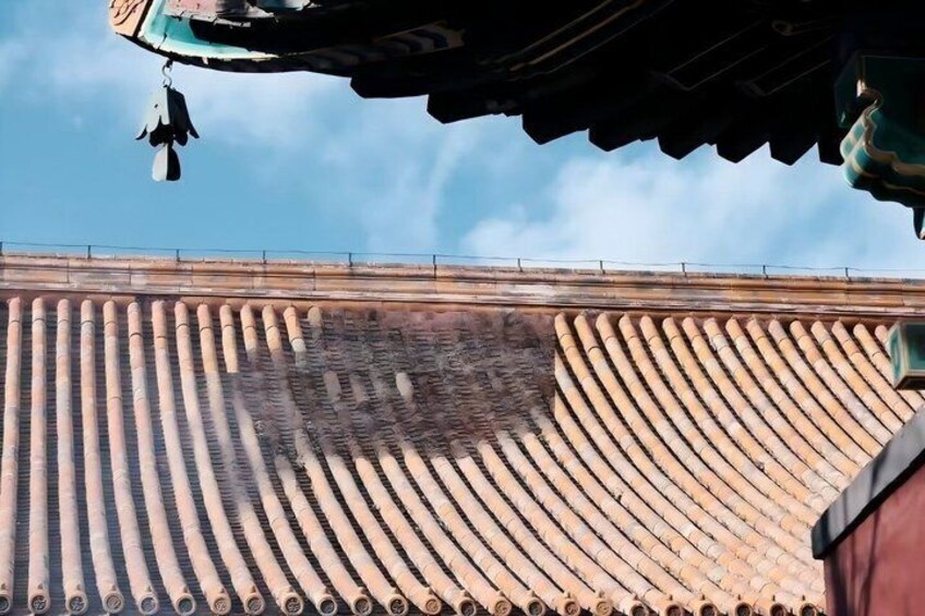 A traditional roof with a circular pattern, a clear sky, and a fence in the background. 3