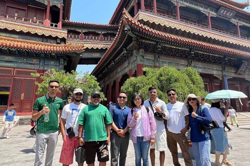 A group of people standing in front of a traditional Chinese building with ornate architecture. 1