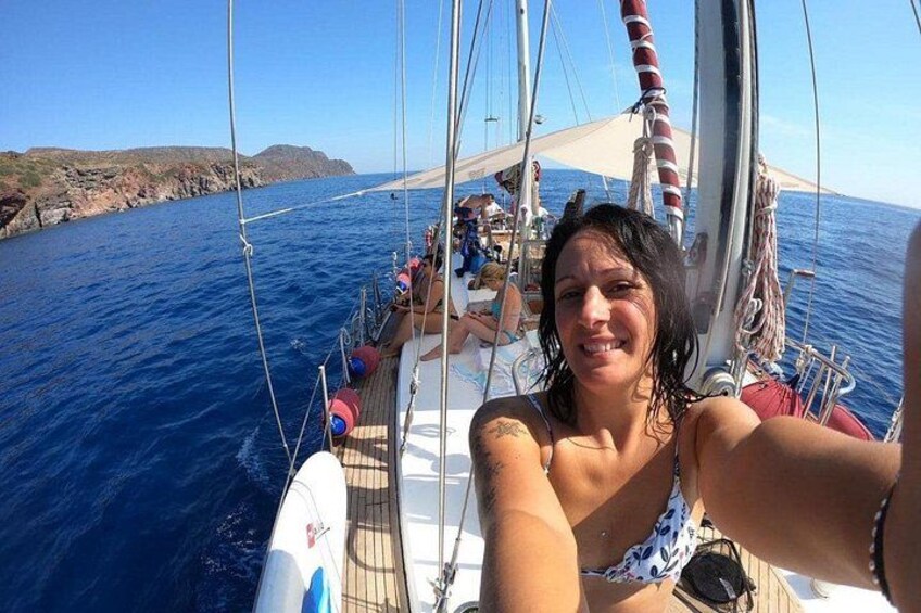 A sailboat on the water with people on deck. 1