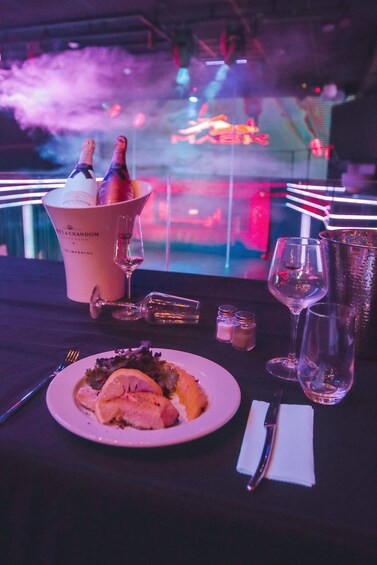 A dining table with a plate of food, a bottle of champagne, wine glasses, and a bucket labeled 'Chandon.' 4