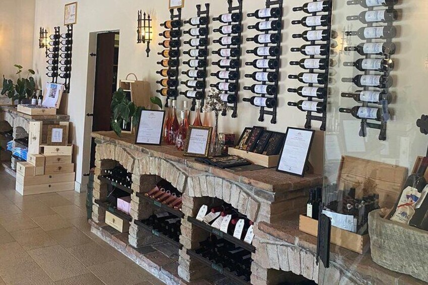 A wine cellar with bottles on shelves and a wine rack on the wall. 2