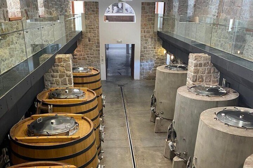 A series of wooden and stone barrels arranged in a row, likely for aging or storing liquids. 3