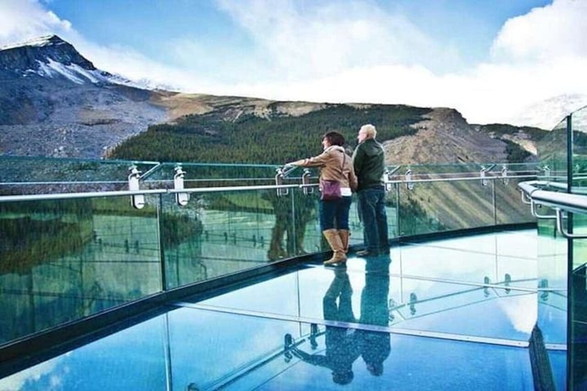 A glass bridge with a mountainous landscape in the background. 4